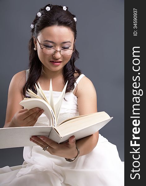 Asian girl in a white dress reads the book. Asian girl in a white dress reads the book