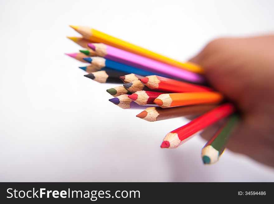 A man holds in his hand colored pencils. A man holds in his hand colored pencils