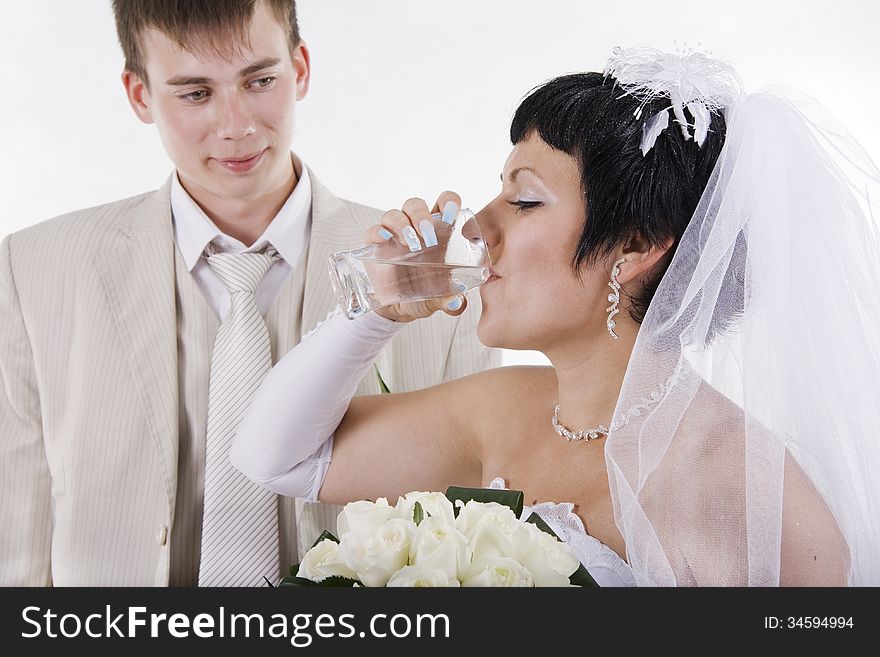 The groom and the bride drink water. White isolated.