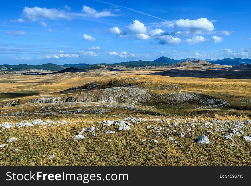 Mountain landscape, view on a mountain valley, distant road and shadows of clouds