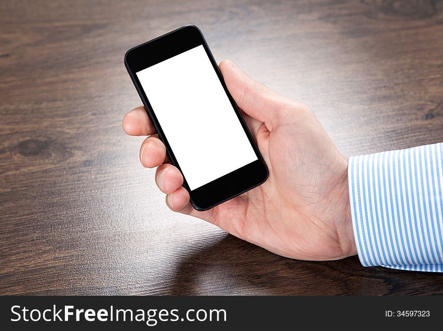 Businessman holding a touch phone with isolated screen over the villages table. Businessman holding a touch phone with isolated screen over the villages table