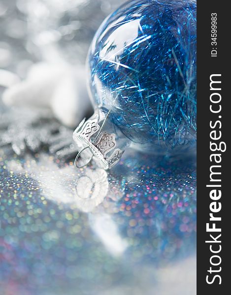 Blue and silver xmas ornaments on bright holiday background with space for text