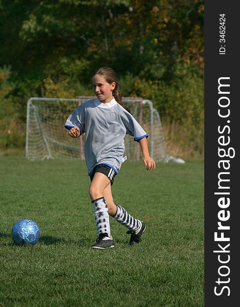 A young girl enjoys a game of soccer. A young girl enjoys a game of soccer