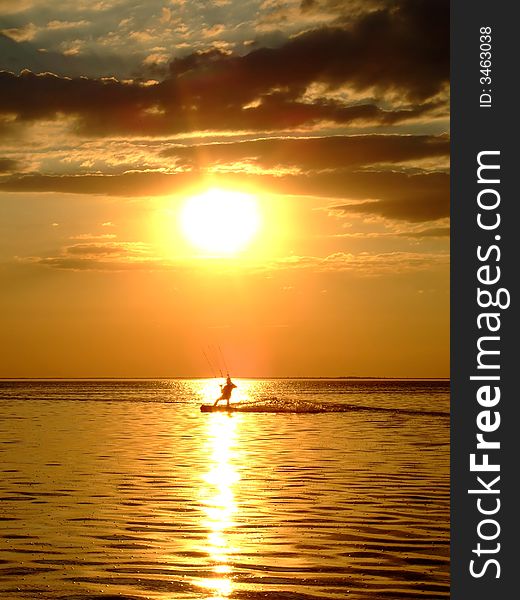 Silhouette of a kitesurf on a gulf on a sunset