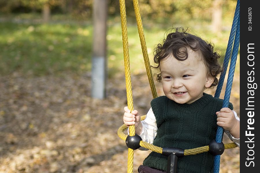 The small child shakes on a swing.