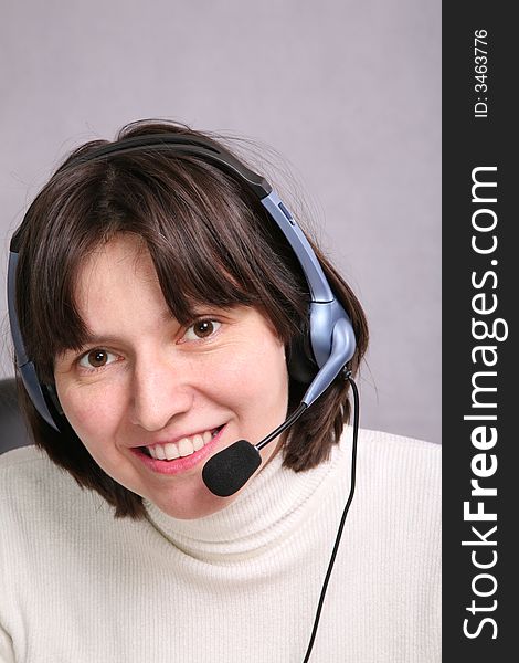 Smiley woman wearing headset on gray background. Smiley woman wearing headset on gray background