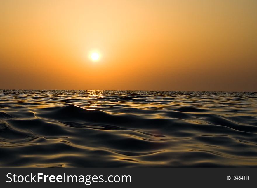 Sunset reflected in waves of the sea