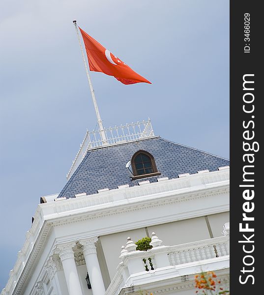A grand building all decked in white with a red flag. Taken in Singapore Istana.
