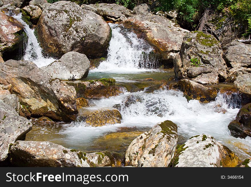 Mountain stream running over mossy rocks in siberia (foothills of Sayan's mountain range)