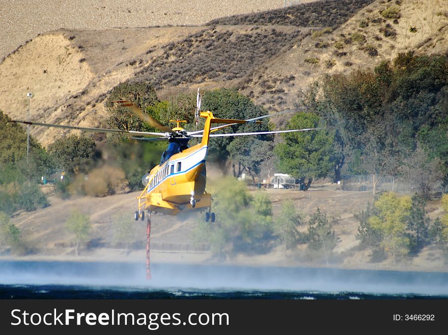 Mist from hose while helicopter hovers over Castaic Lake California during brush fires. Mist from hose while helicopter hovers over Castaic Lake California during brush fires
