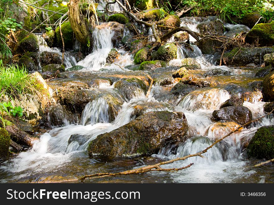 Mountain stream running over mossy rocks in siberia (foothills of Sayan's mountain range)