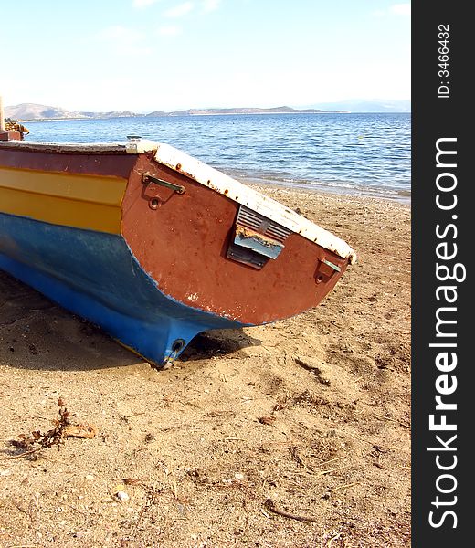 A part of a fishing boat out on the sand of a beach