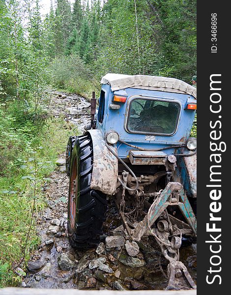 Tractor on the siberian mountain road. Tractor on the siberian mountain road