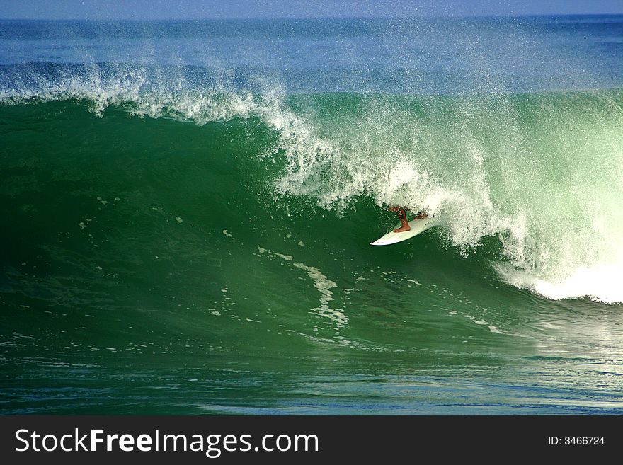 An image of a surfer doing a maneuver in the barrel. An image of a surfer doing a maneuver in the barrel.