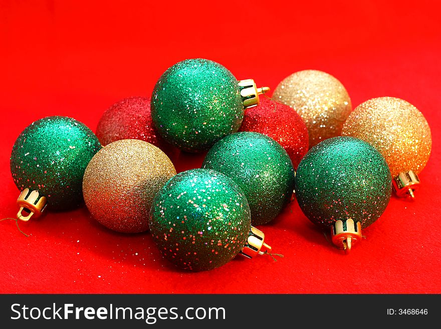 Green and gold christmas balls on a red background