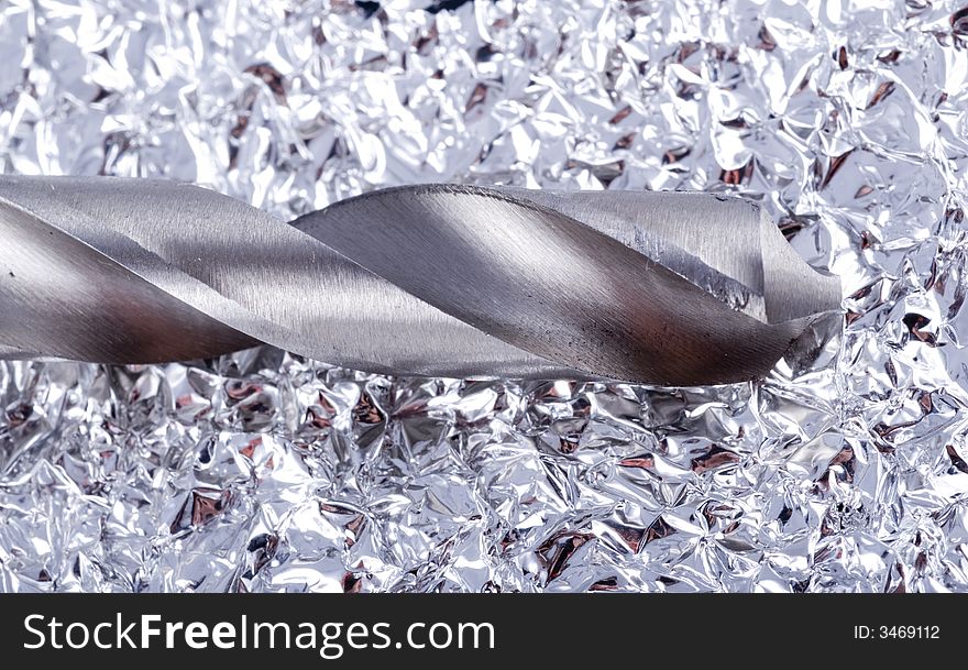 Drill bit on silver backround