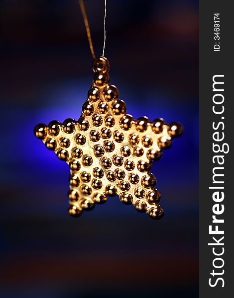 Golden hanging star on blue changing background. Golden hanging star on blue changing background