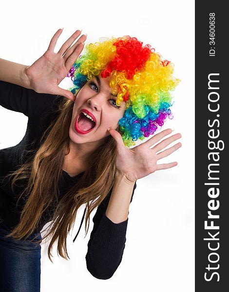 On the head of the cheerful girl multi-colored wig. Isolated on white.