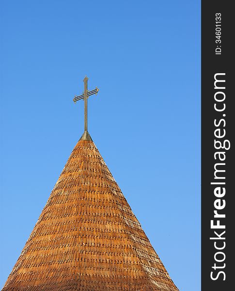 Cross in top of a roof tower on the blue sky. Cross in top of a roof tower on the blue sky