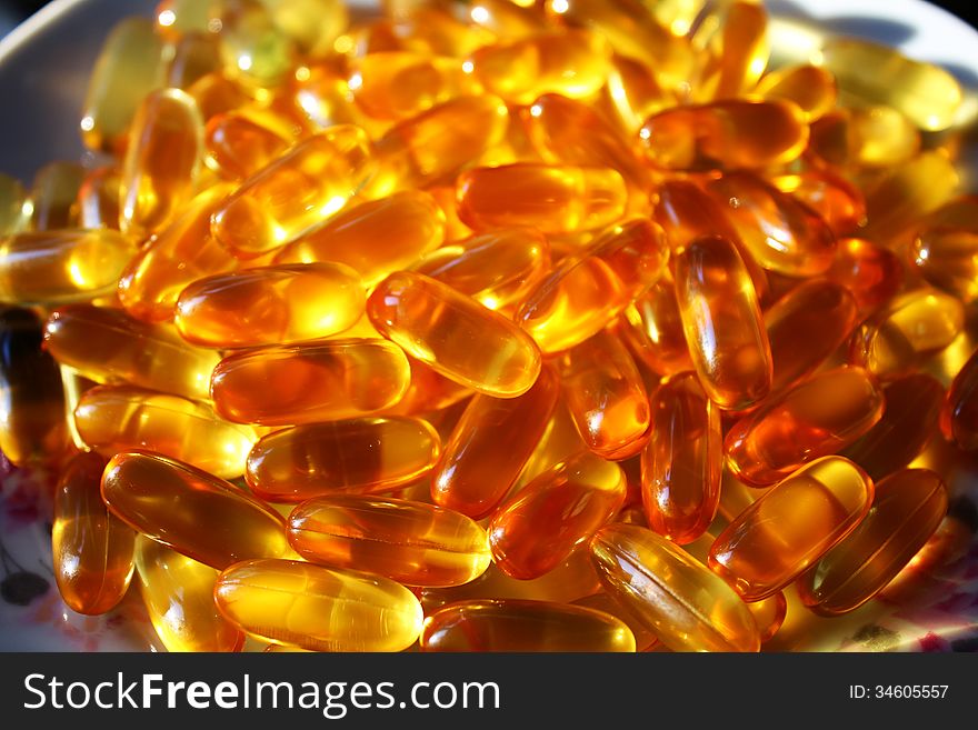 Amber pile of gel vitamin fish oil supplement capsules