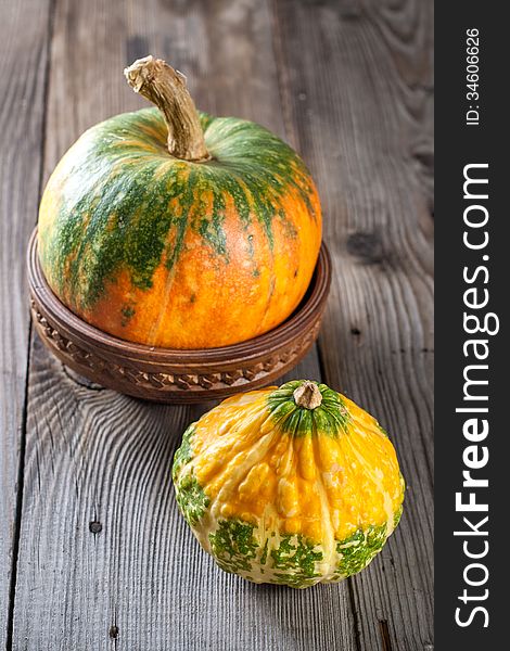 Autumn pumpkins with leaves on wooden board