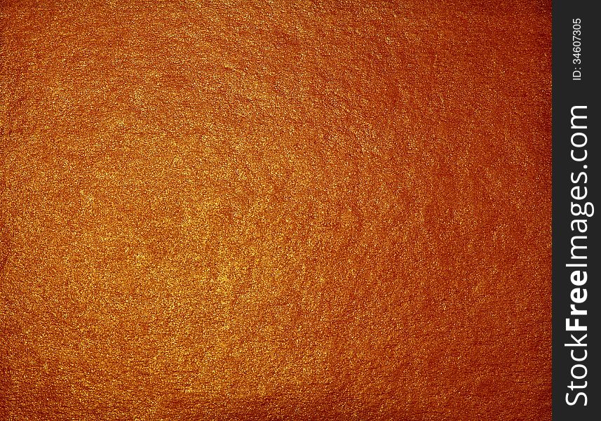 Shiny golden brown grainy surface of the lighted paper or wall. Shiny golden brown grainy surface of the lighted paper or wall