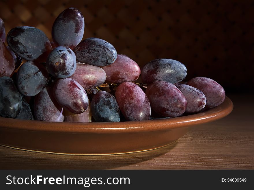 Bunches of ripe grapes on a ceramic plate. Bunches of ripe grapes on a ceramic plate