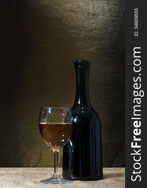 Bottle and glass of white wine on a old stone background. Bottle and glass of white wine on a old stone background