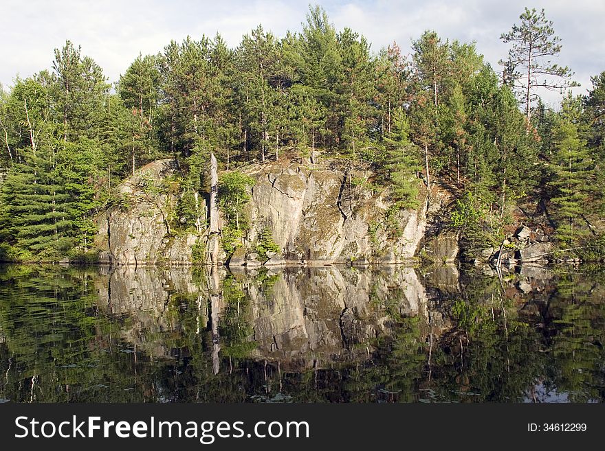 Rock face reflection on a calm evening on a northern lake