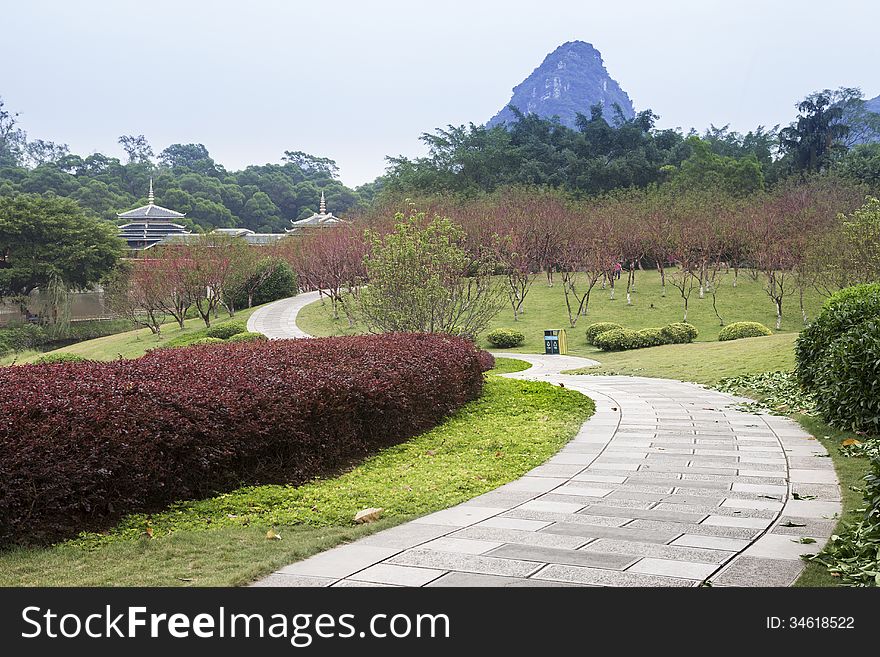 Garden view, There are trees and flowers everywhere, Chinese buildings and distant peaks.Longtan Park in Liuzhou,China. Garden view, There are trees and flowers everywhere, Chinese buildings and distant peaks.Longtan Park in Liuzhou,China.