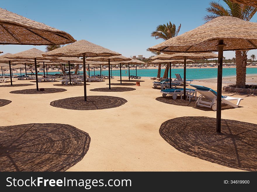 Beach with chaise lounges and sunshades. Beach with chaise lounges and sunshades