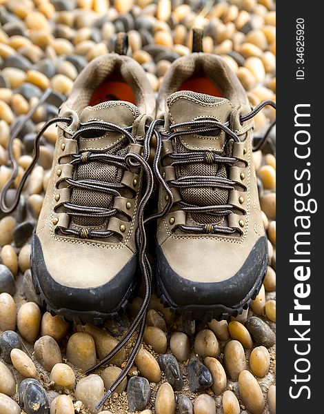 A pair of hiking shoes on cobble floor. A pair of hiking shoes on cobble floor