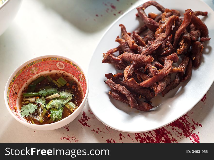 Fried pork and sauce on table .