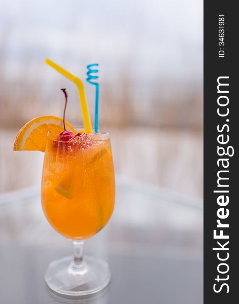 Orange juice in wine glass with cherry fruit. Orange juice in wine glass with cherry fruit