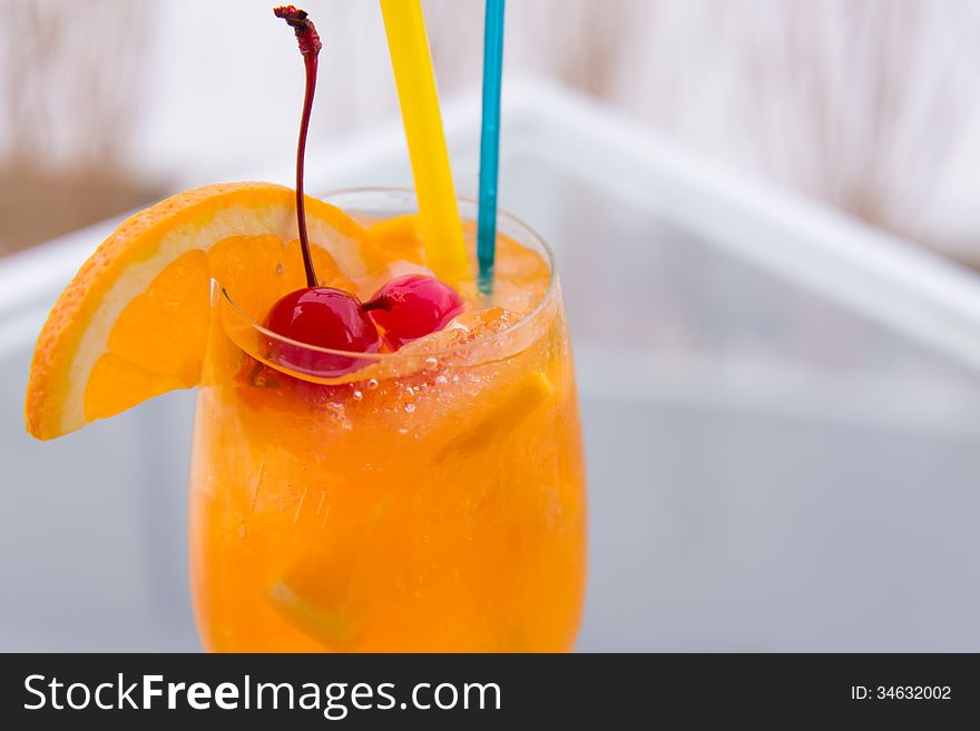 Orange juice in wine glass with cherry fruit. Orange juice in wine glass with cherry fruit