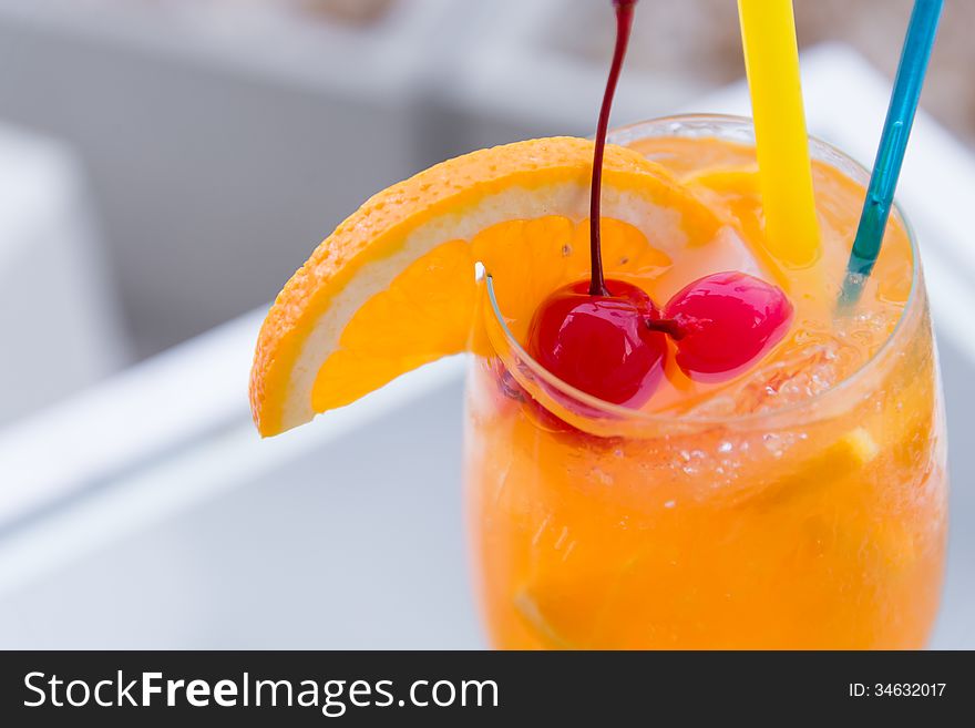 Orange juice in wine glass with cherry fruit. Orange juice in wine glass with cherry fruit