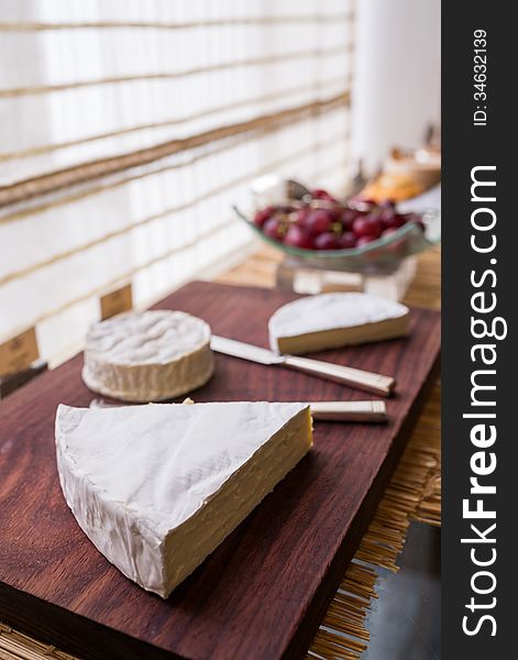 Variety of cheese on wooden board buffet line
