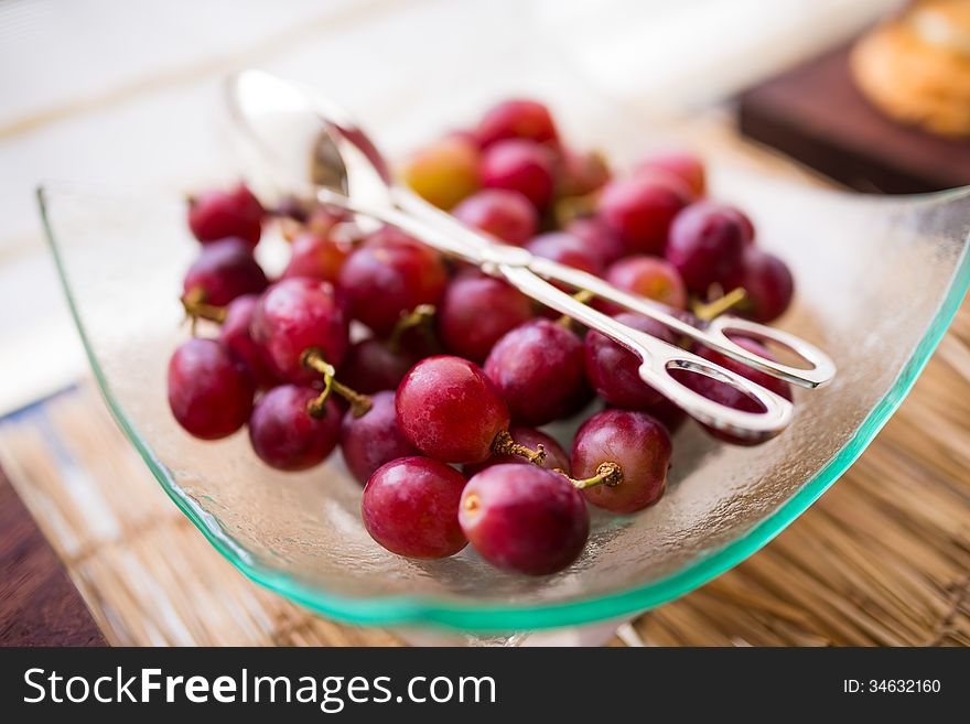 Red ripe grape fruit in the glass plate