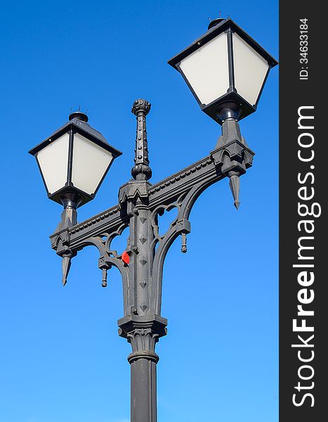 Metal street lamp against the blue sky