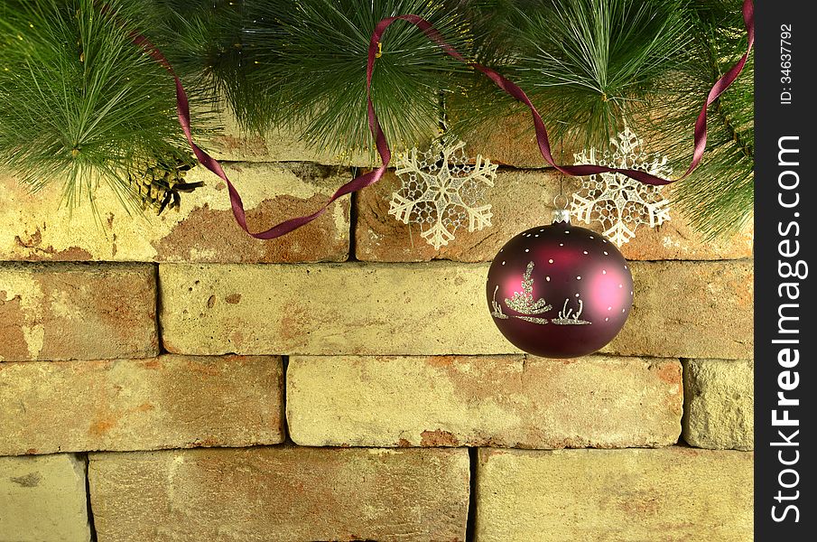 Purple bauble on brick wall