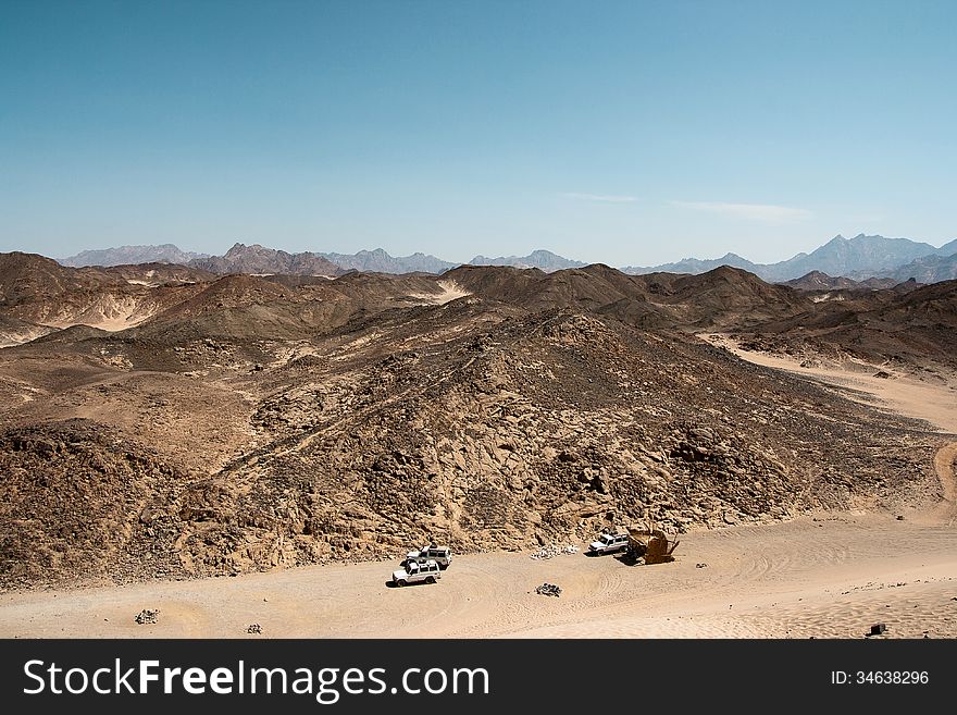 Three cars in the desert africa mountains in the background. Three cars in the desert africa mountains in the background