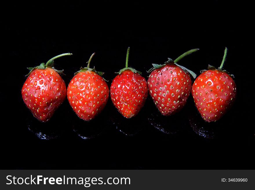 A bowl of strawberry, over black background