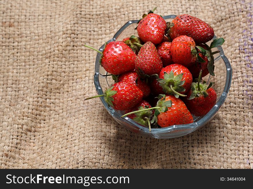 A bowl of strawberry, at natural sack cloth