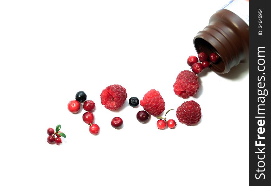 Berries spilling out of pills bottle isolated on white