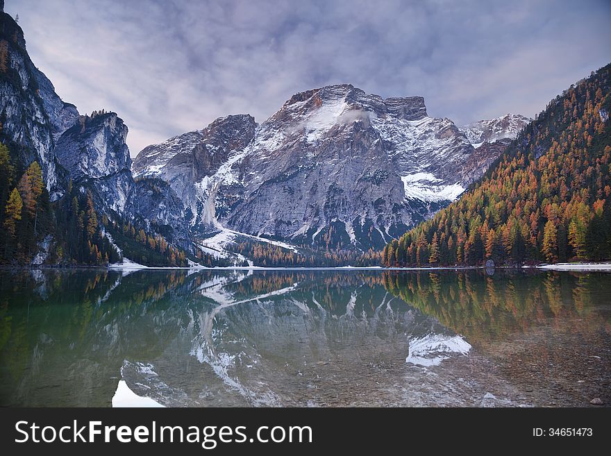 Idyllic lake surrounded by colourful forest in the Italian Alps during autumn morning. Idyllic lake surrounded by colourful forest in the Italian Alps during autumn morning.