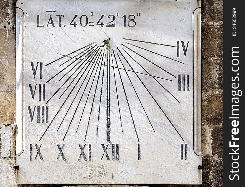 Ancient sundial on the wall a bell tower - Italy