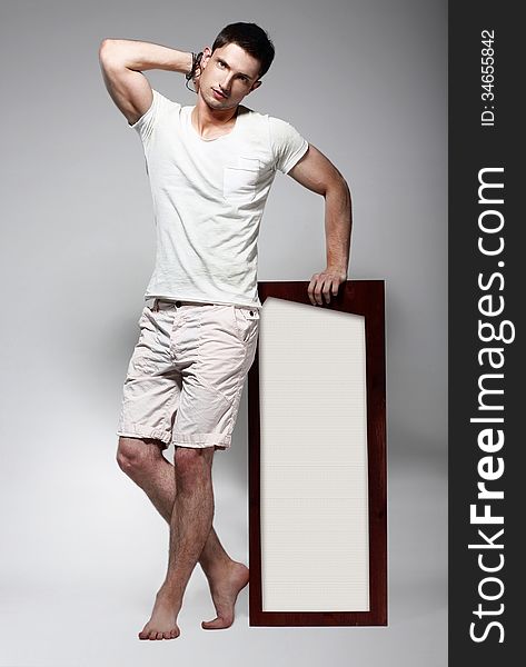 Fashion Male posing with Board in Studio. Fashion Male posing with Board in Studio