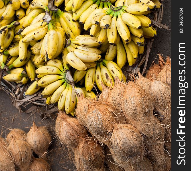 Tropical fruits natural background. Fresh coconuts and bananas at market place