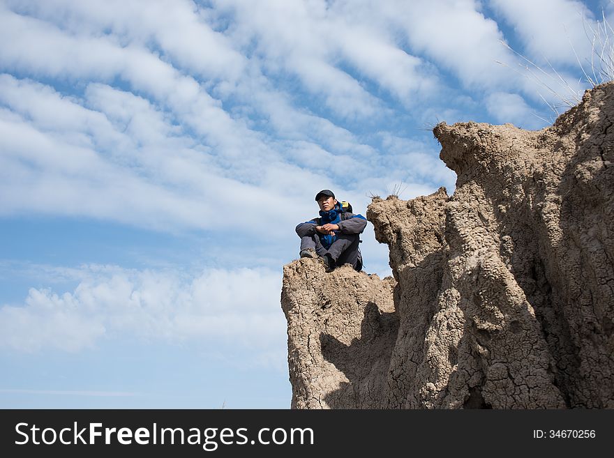 Sitting on a cliff resting hikers. Asian Youth. Sitting on a cliff resting hikers. Asian Youth