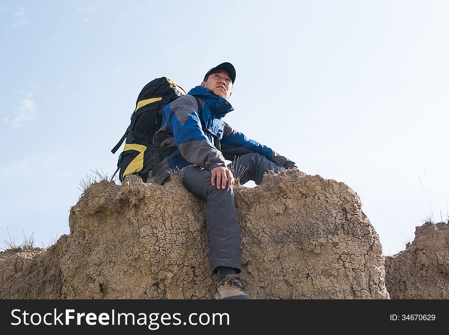 Sitting on a cliff resting hikers. Asian Youth. Sitting on a cliff resting hikers. Asian Youth